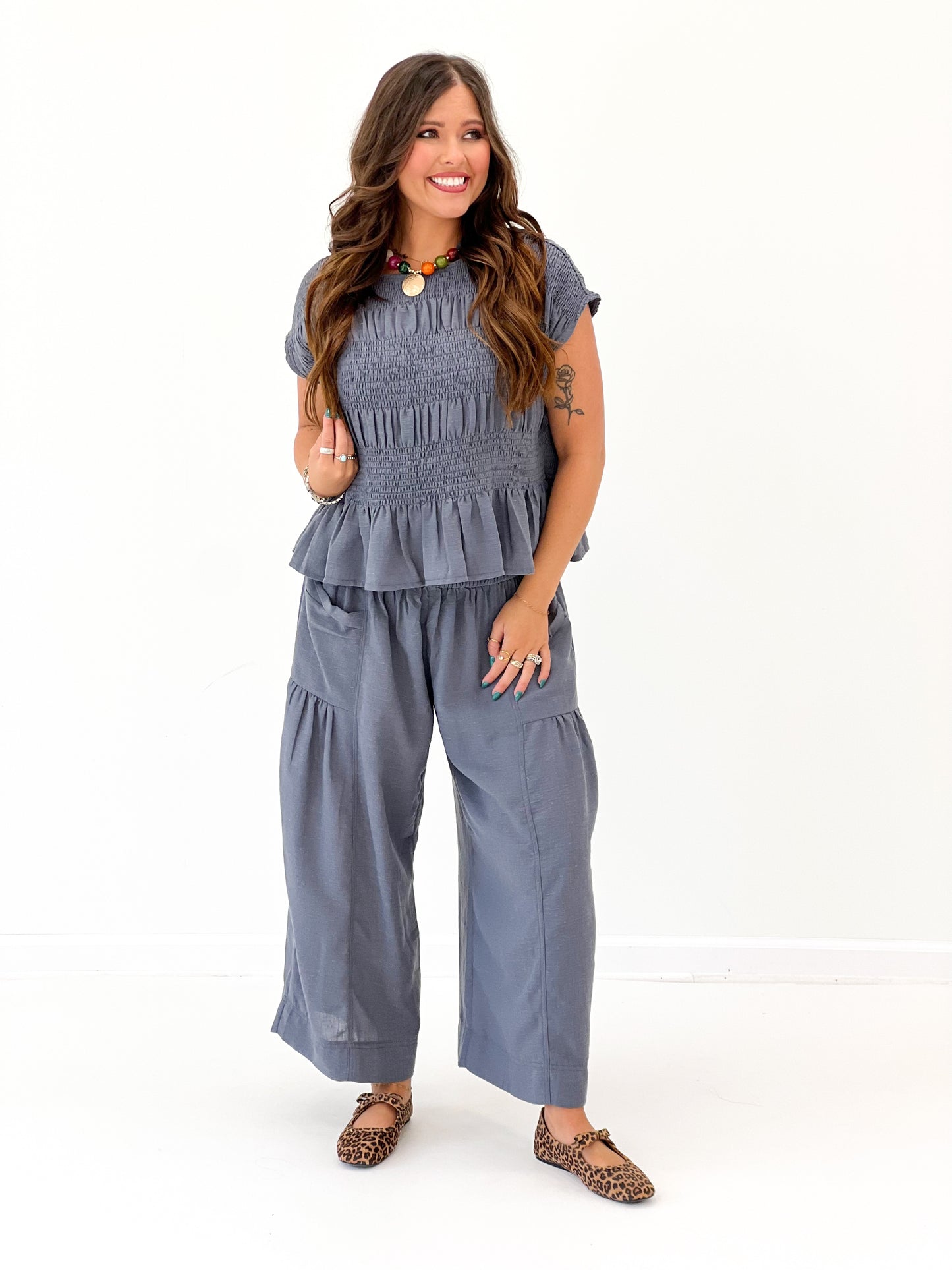 Deep blue ruched neckline top with short sleeves and layered ruffle hem