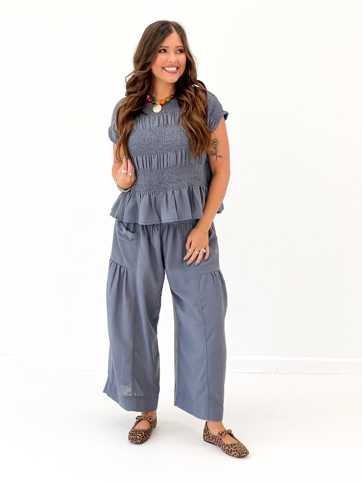 Deep blue ruched neckline top with short sleeves and layered ruffle hem
