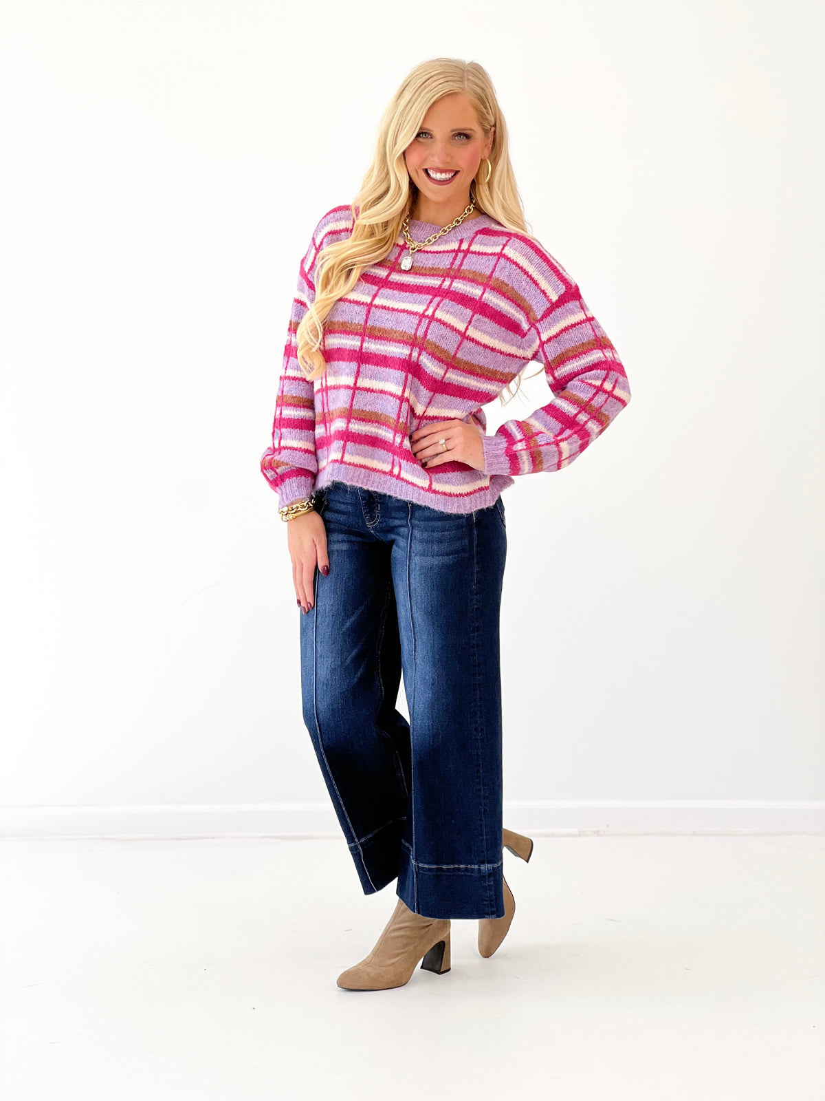 Pink plaid crew neck sweater with long sleeves and multicolor stripe pattern
