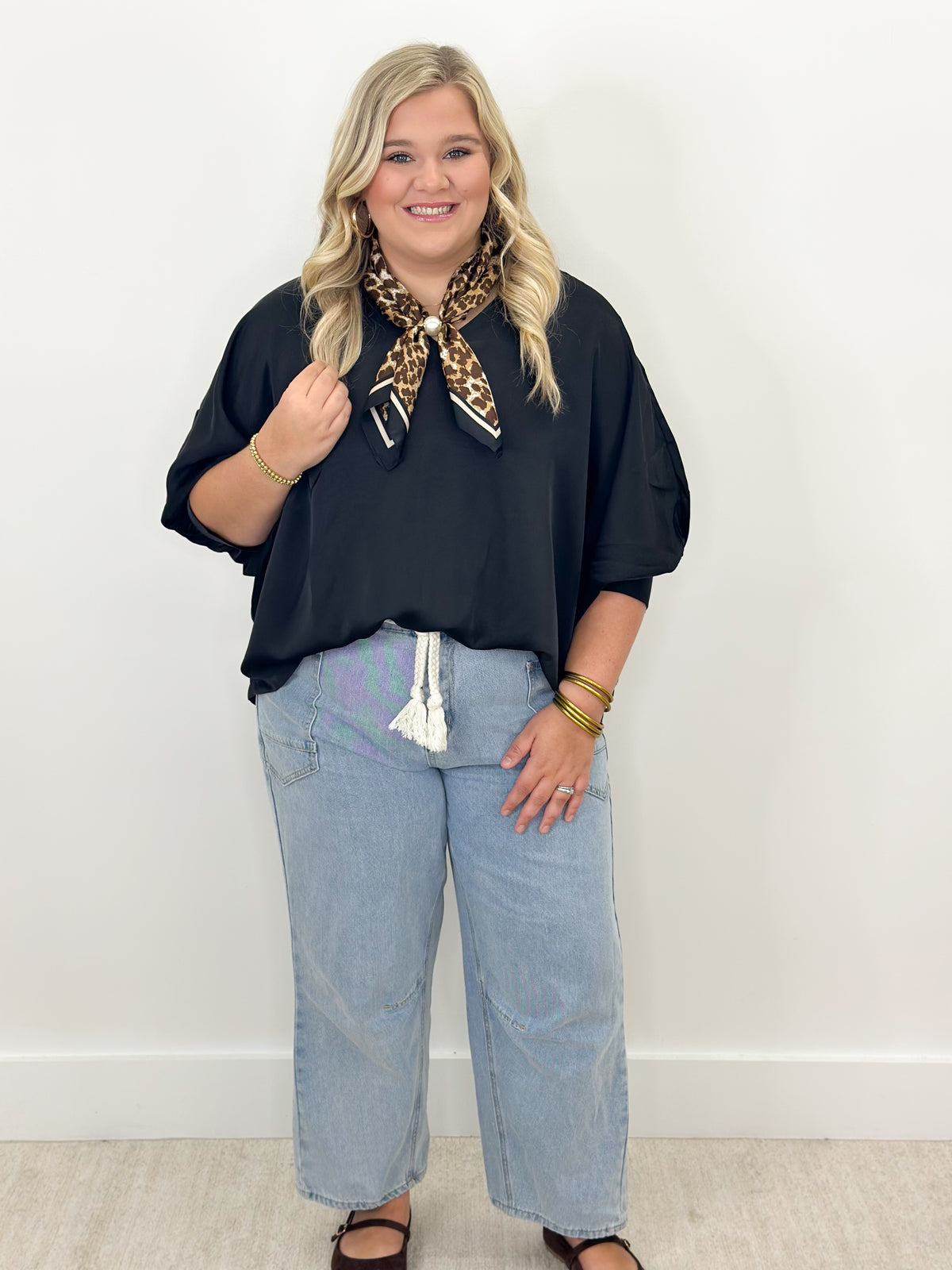 Black oversized v-neck top with cuffed batwing sleeves and relaxed drape