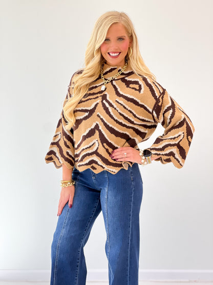 Animal print knit top with mock neck and scalloped trim at cuffs and hem