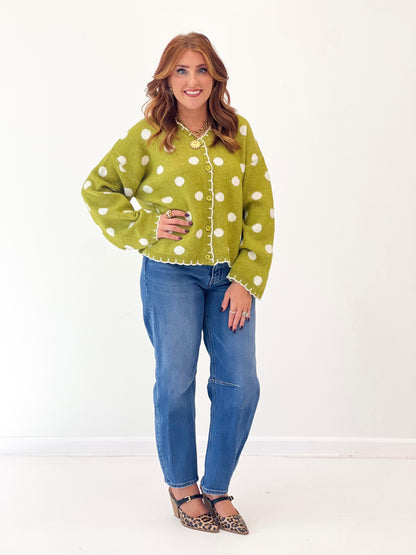 Green polka dot button-front cardigan with long sleeves and scalloped cuffs.