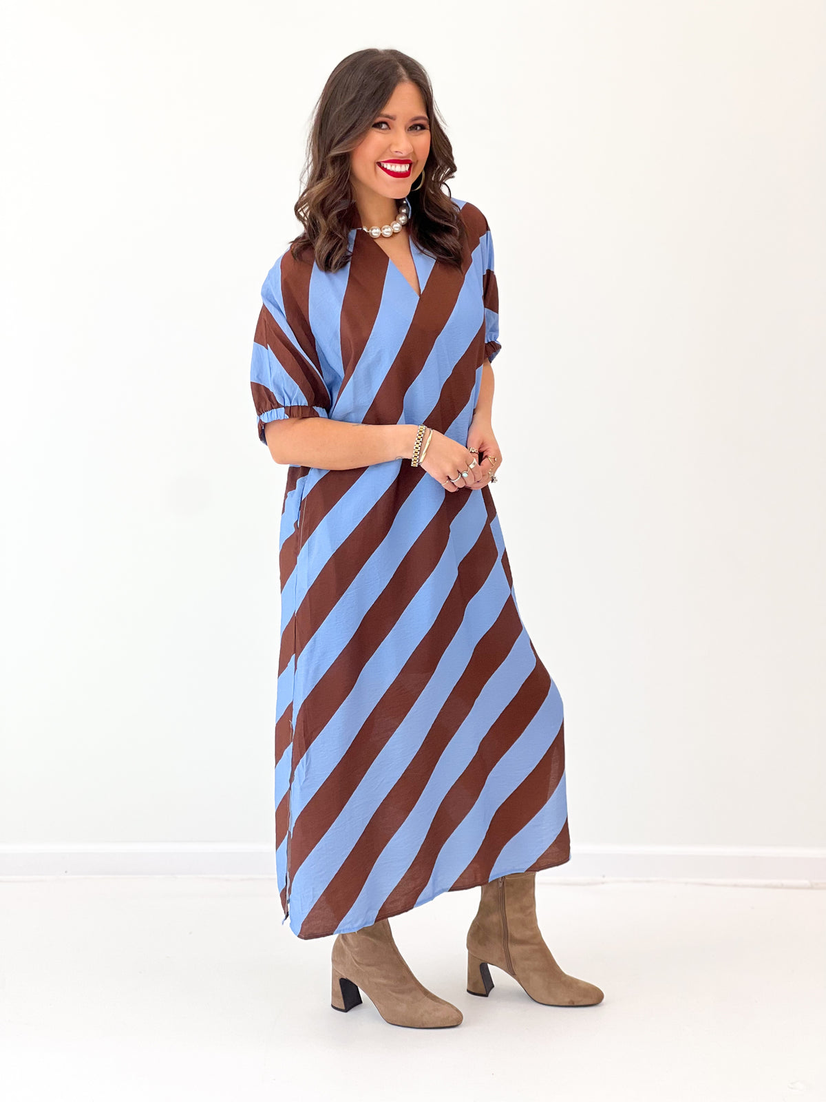 Light blue and rust striped dolman sleeve V-neck midi dress, hand at waist