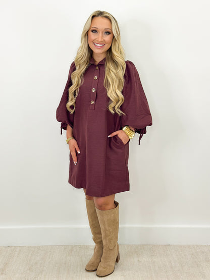 Merlot balloon-sleeve stand-collar mini dress with button front, worn with tall boots