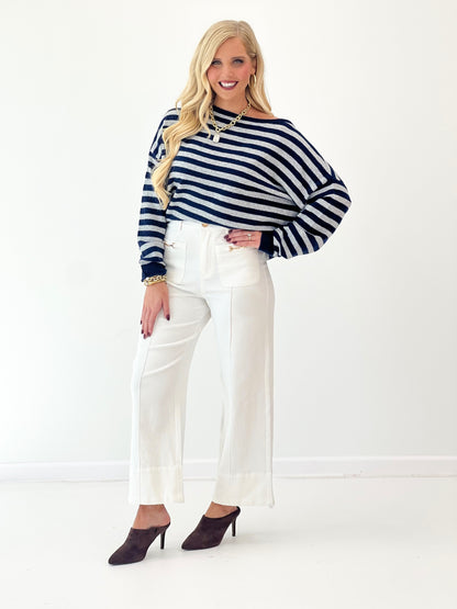 Navy and white striped off-shoulder sweater with long sleeves and ribbed cuffs