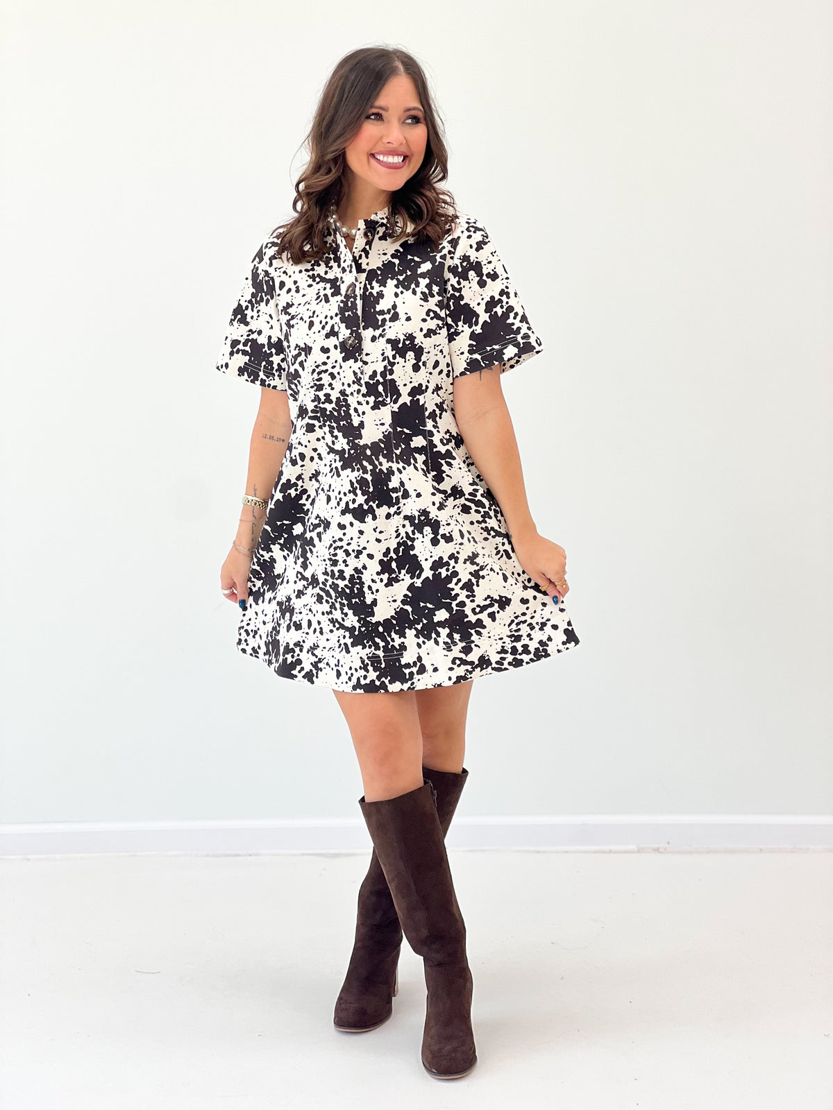 Cow print button-up short-sleeve dress, cream base with black abstract spots and flared hem