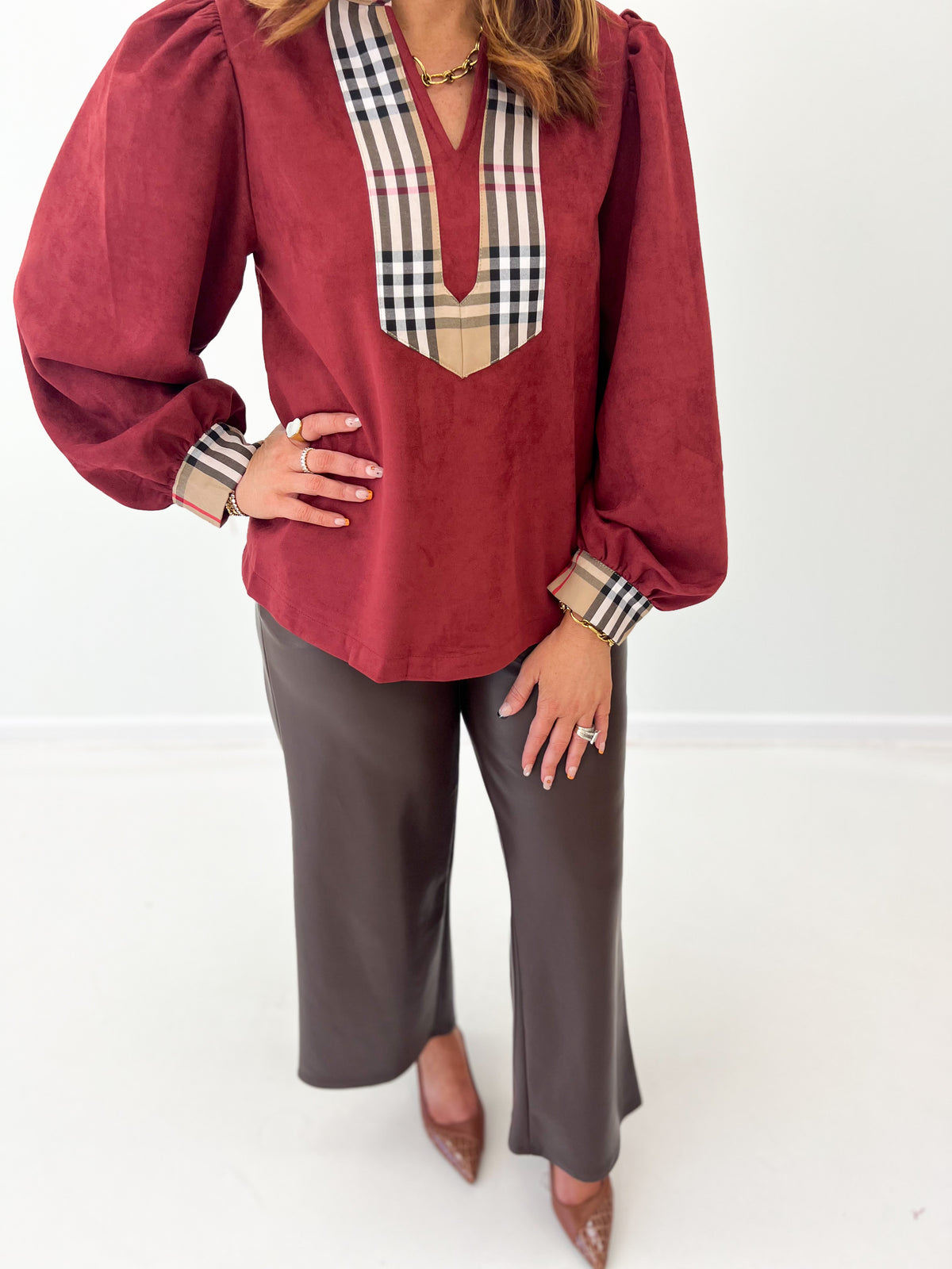 Burgundy faux suede puff-sleeve top close-up: plaid V yoke and wrist cuffs