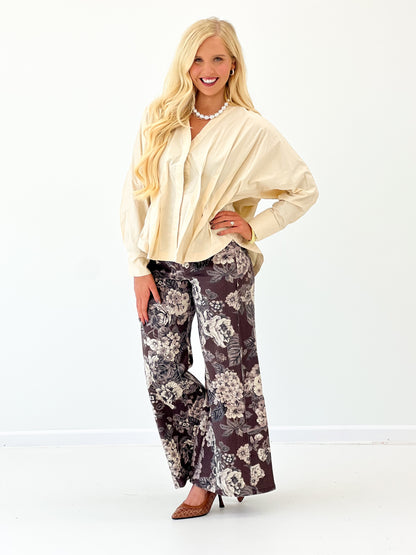 Cream V-neck pleated-waist blouse with long sleeves and gathered puff shoulders