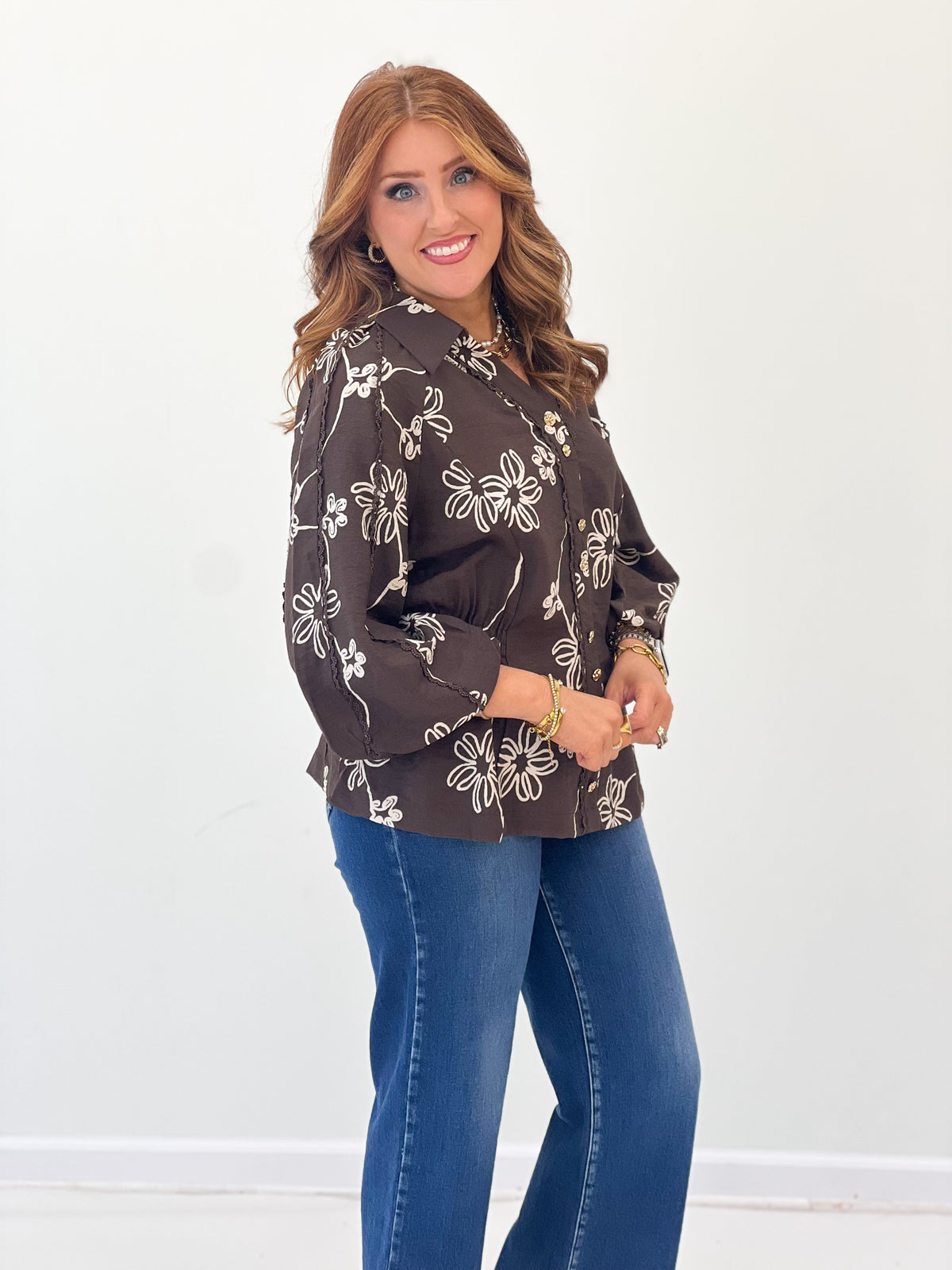 Dark brown floral button-front blouse with long sleeves and curved hem