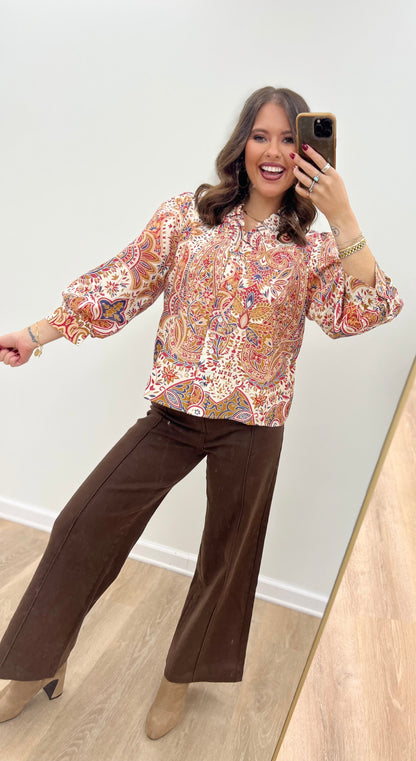 Cream floral button-down blouse with ruffled neck and long puff sleeves