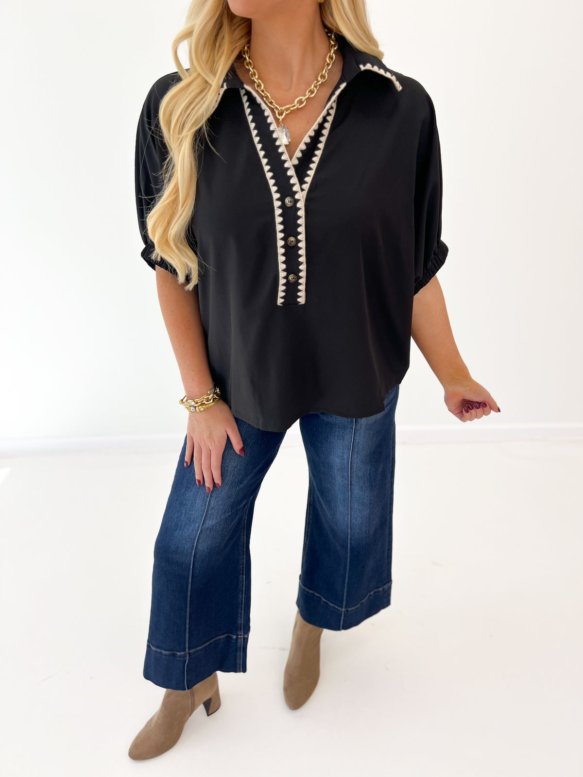 Black V-neck top with contrast trim, dolman sleeves, and relaxed fit