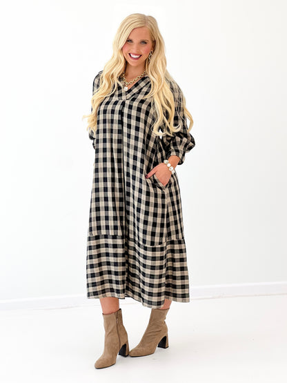 Black-and-white checkered midi dress with open collar and flowing skirt