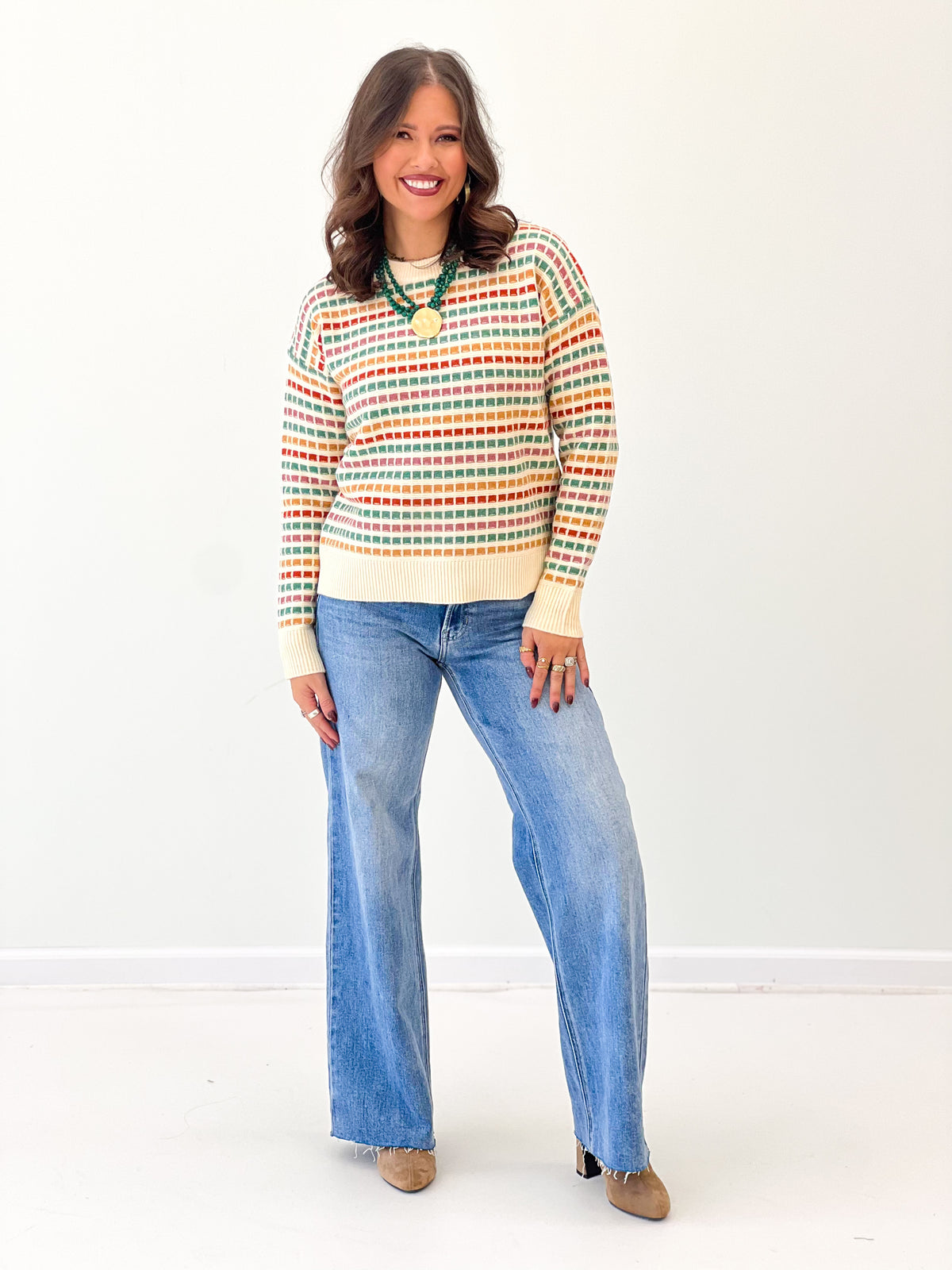 Multi-color striped sweater with crew neck and ribbed cream bottom hem, long sleeves