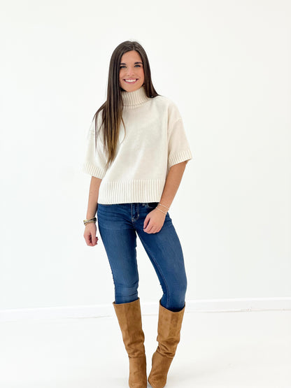 Off-white short-sleeve turtleneck knit sweater with ribbed waistband