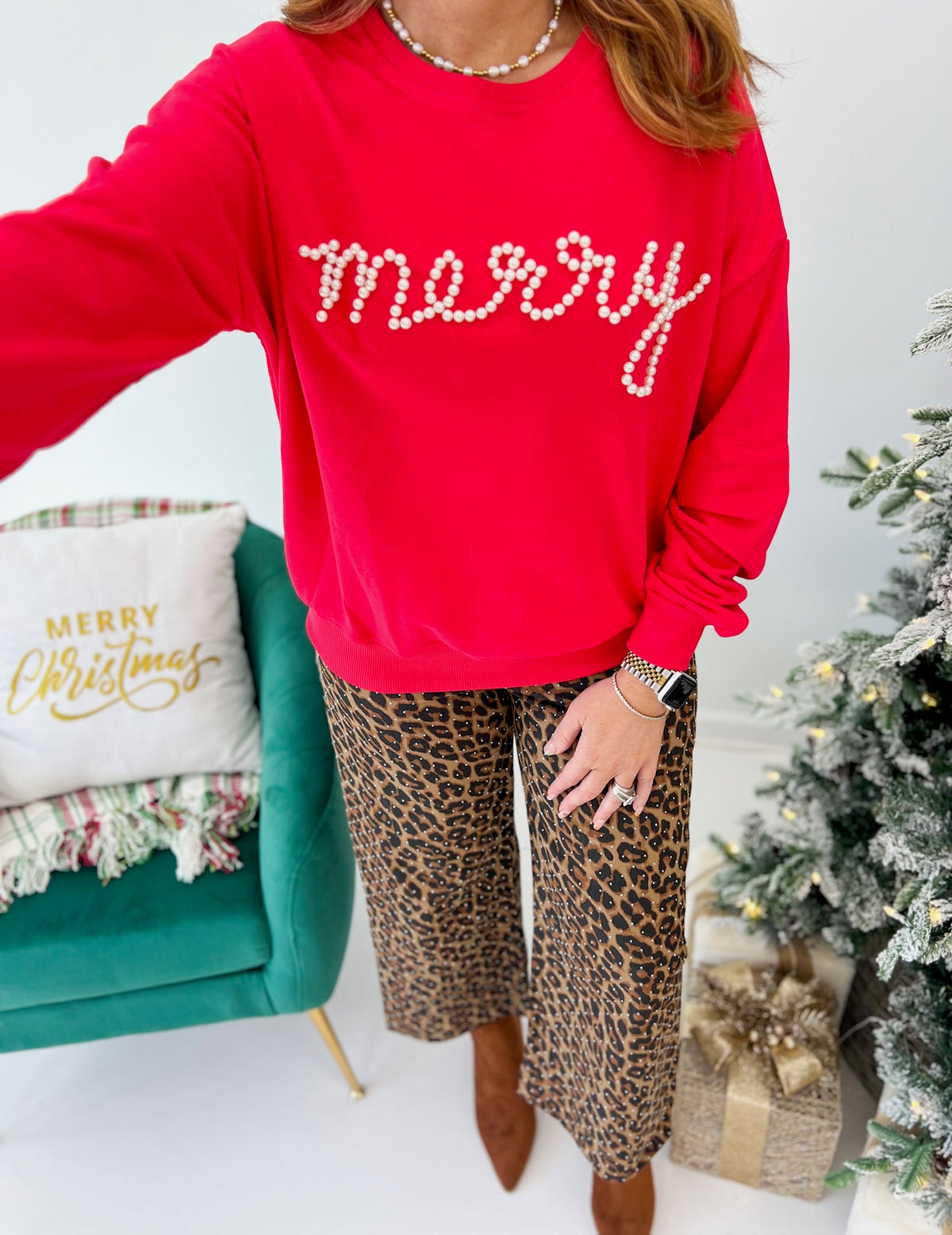 Red crewneck sweatshirt with pearl 'merry' lettering on the front.