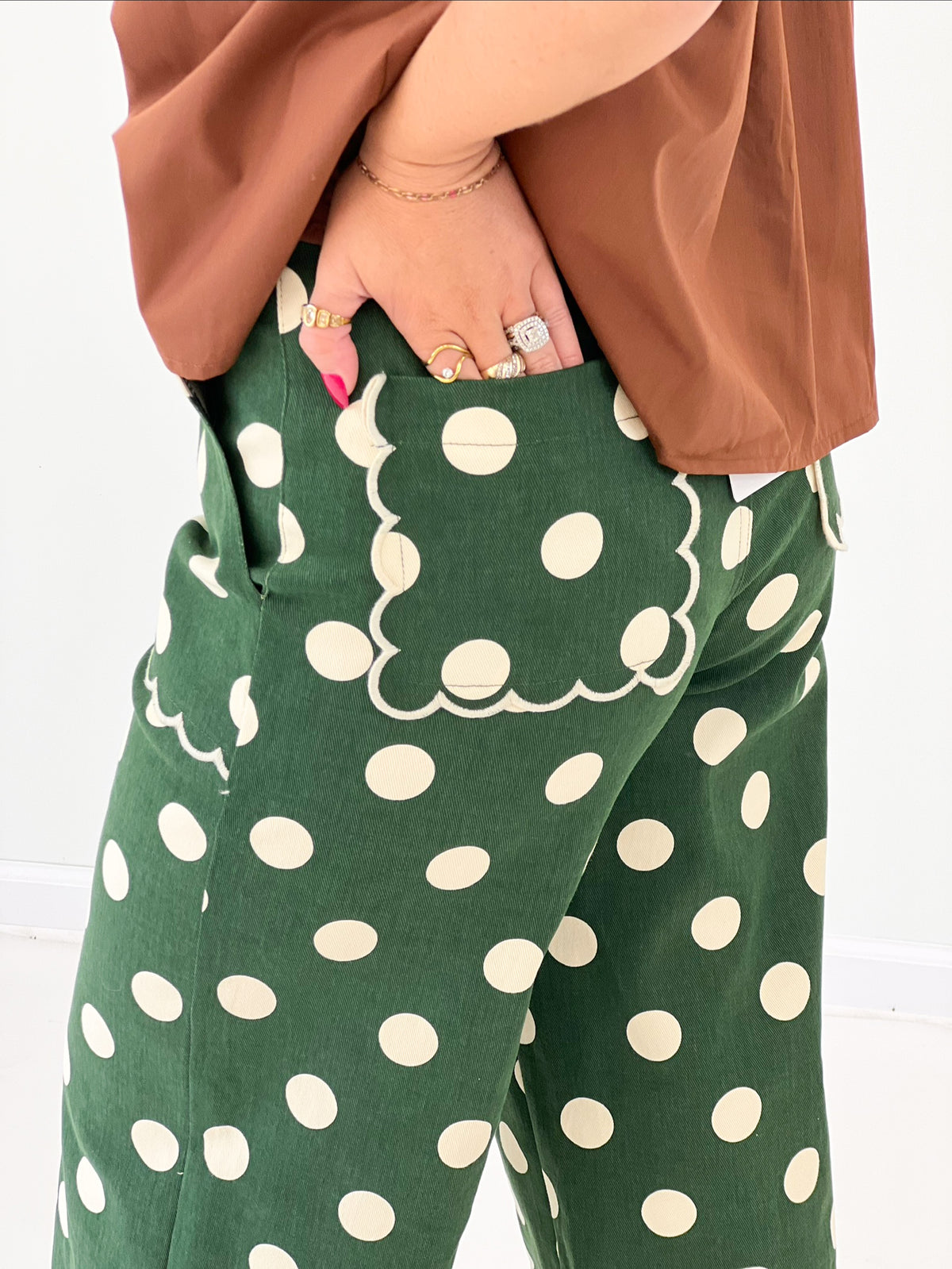 Green polka dot wide-leg pants with scalloped hem and side pockets