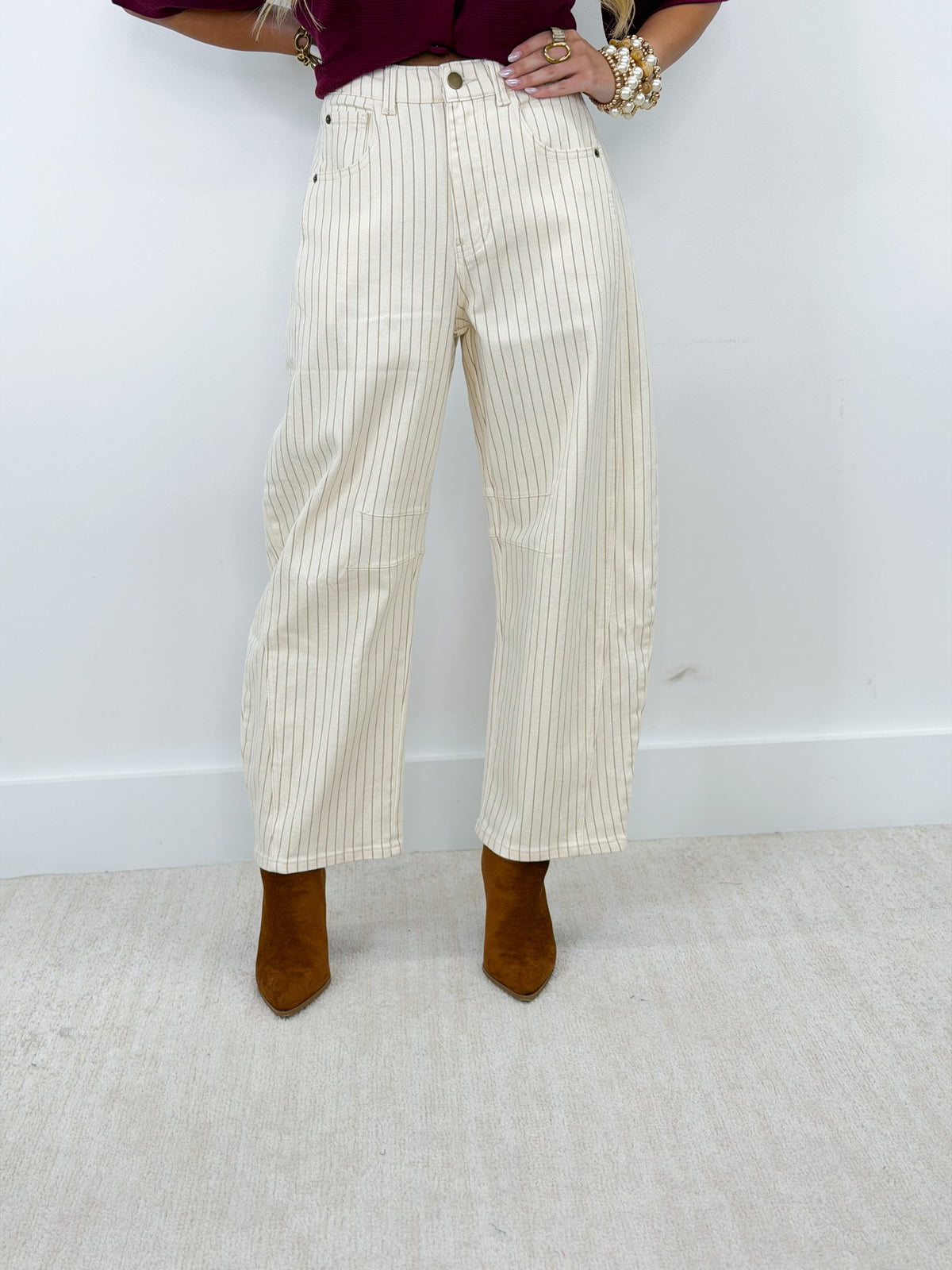 Cream pinstripe barrel pants with front button closure and side pockets