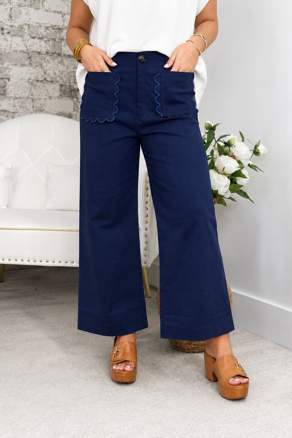 Navy cropped wide-leg pants with scalloped front pockets and button closure