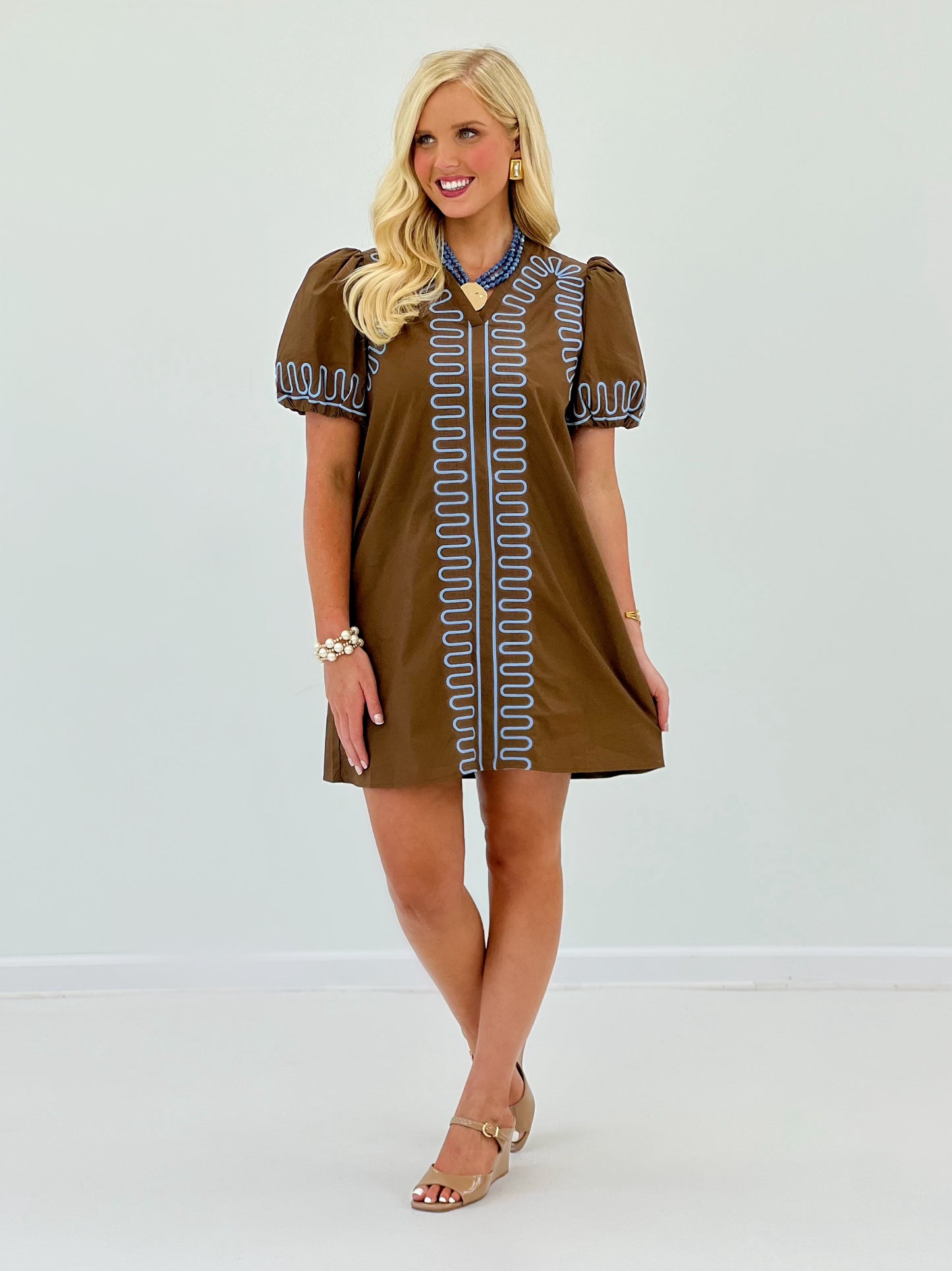Brown short-sleeve dress with blue embroidered trim and scalloped border, above-knee