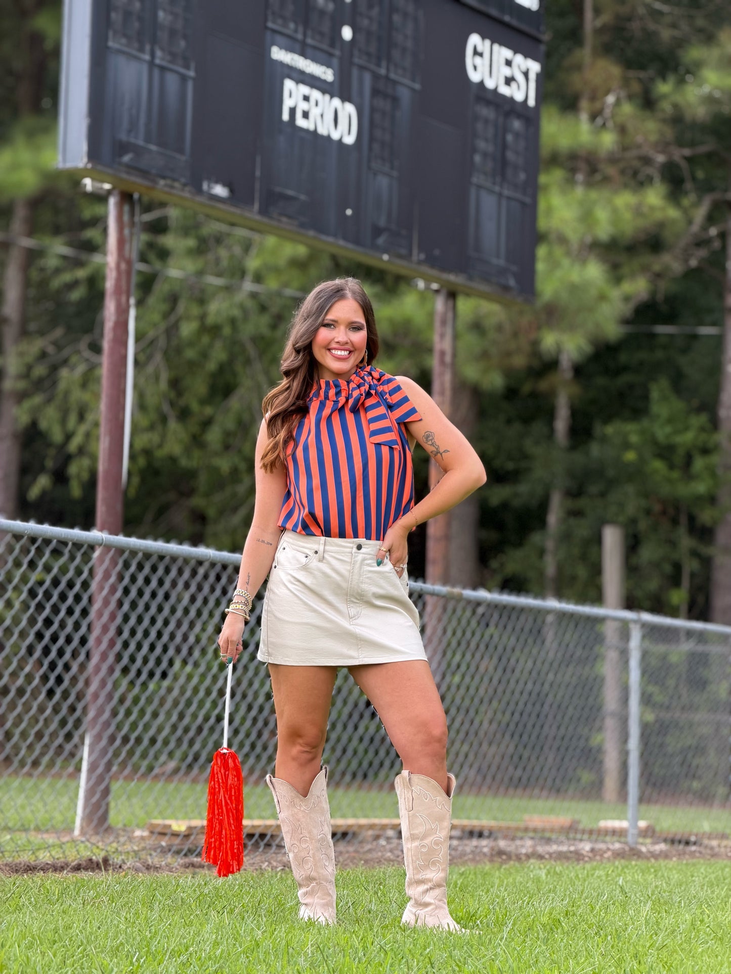 Navy striped sleeveless top with ruffled tie-neck collar, slight side angle
