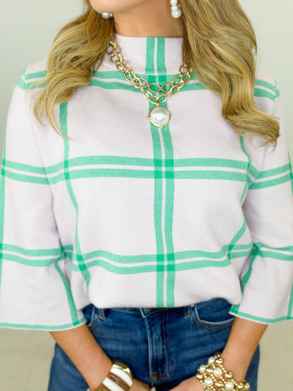 White plaid mock neck sweater with green vertical and grid stripes, neckline detail