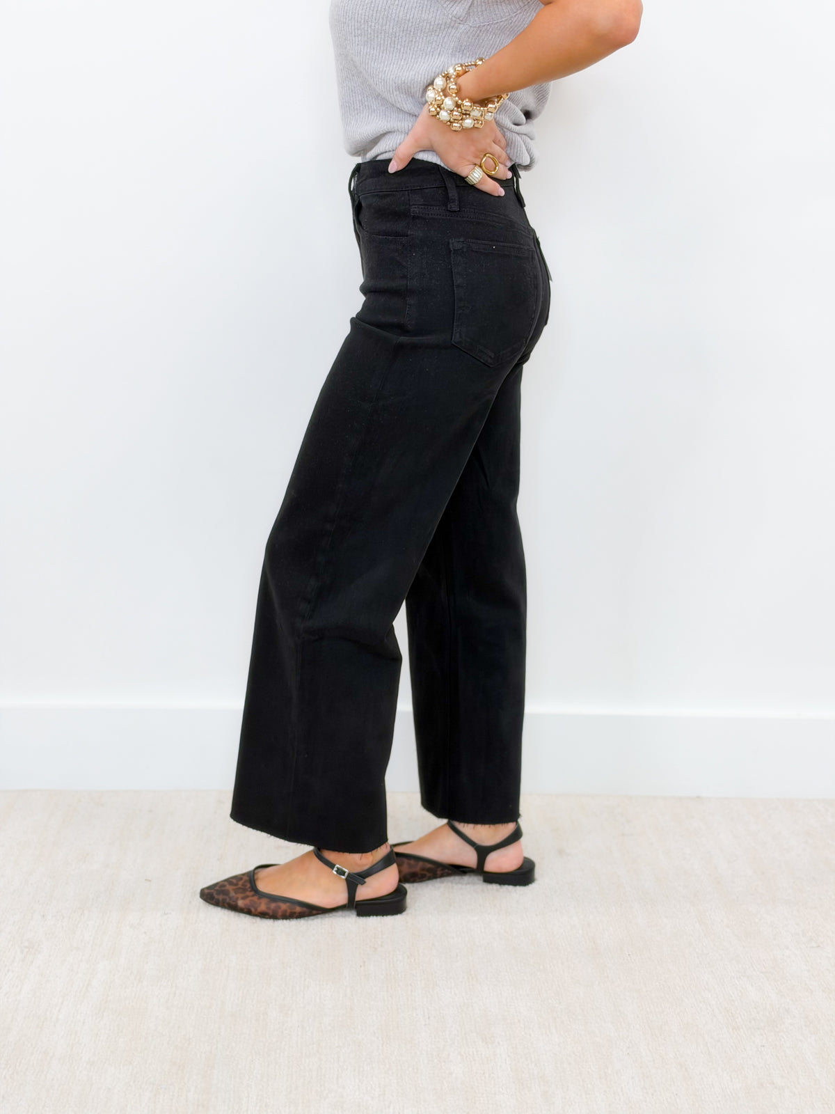 Black high-rise crop wide-leg jeans, side view with wide straight legs