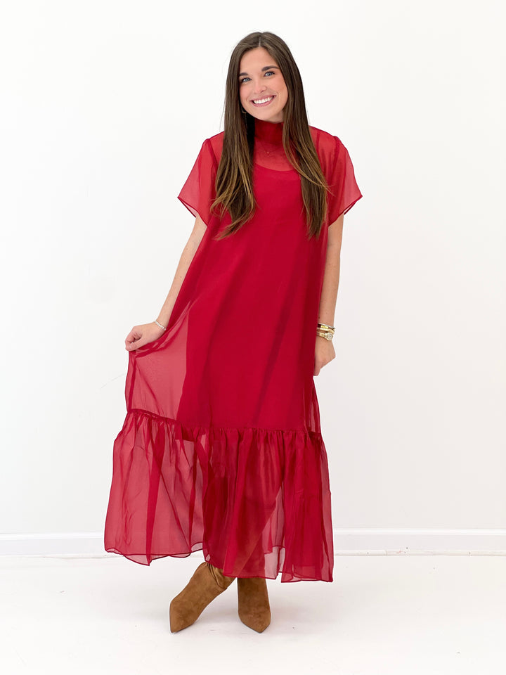 Red chiffon midi dress on model: high neck, flutter sleeves, and flowing layered hem