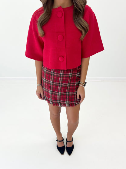 Red short-sleeve sweater jacket with round button front and scalloped-looking collar edge