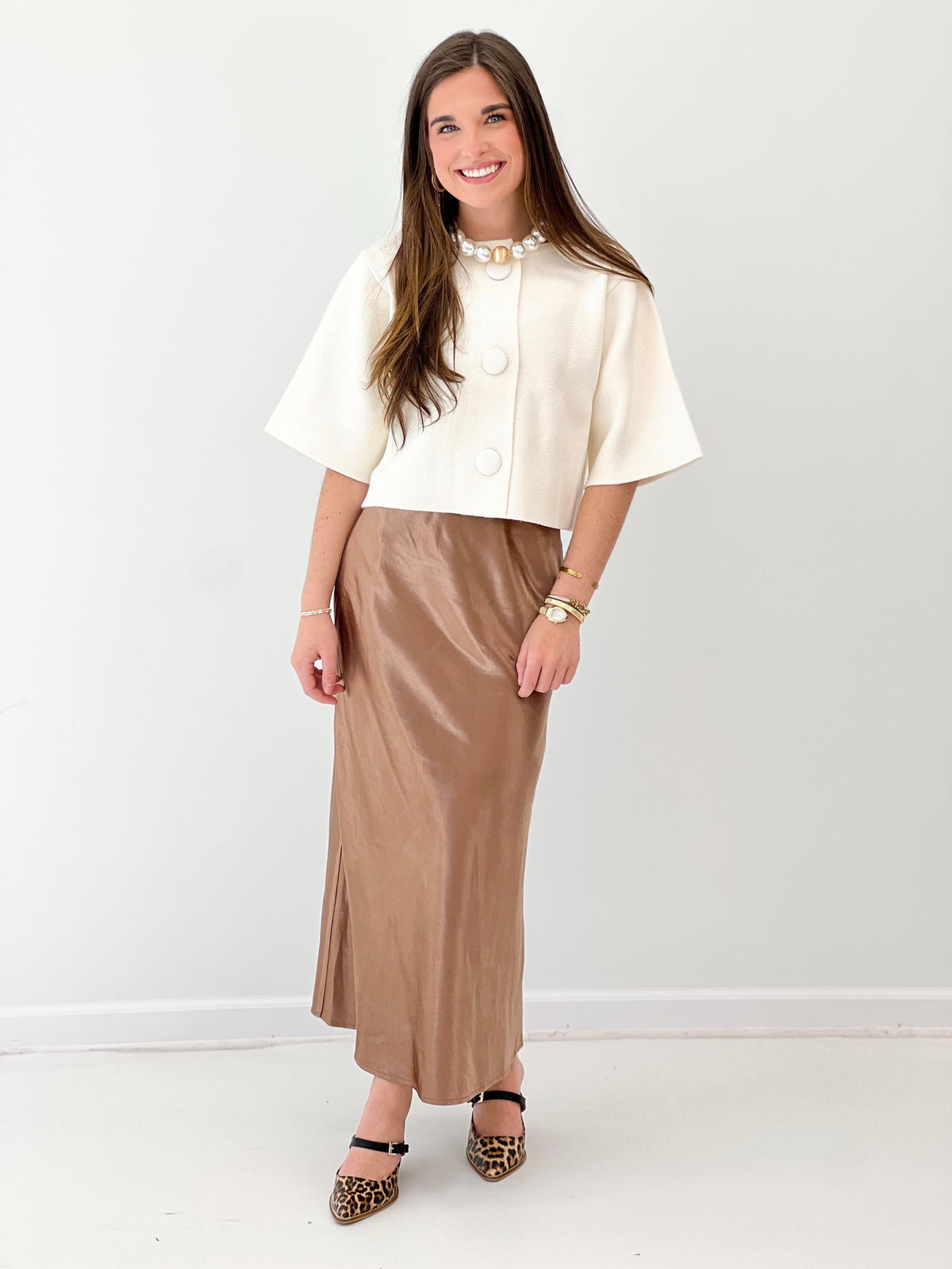 Cream short-sleeve button-front sweater jacket with front round buttons and open neckline