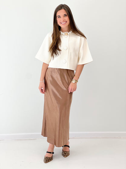 Cream short-sleeve button-front sweater jacket with front round buttons and open neckline