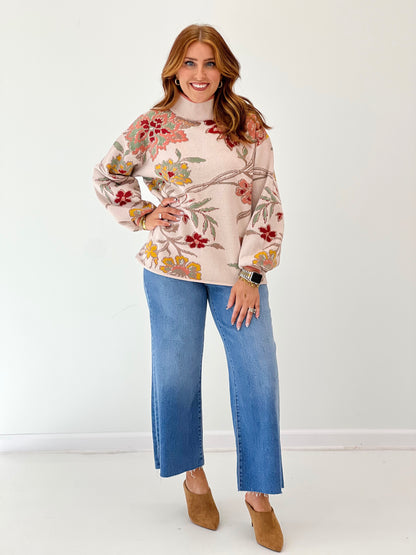 Beige floral jacquard knit mock neck sweater with long sleeves and colorful flower pattern