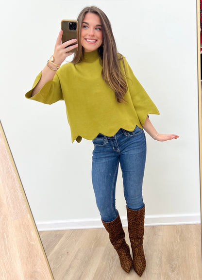 Bright green mock neck sweater with scalloped hem edge and flared short sleeves