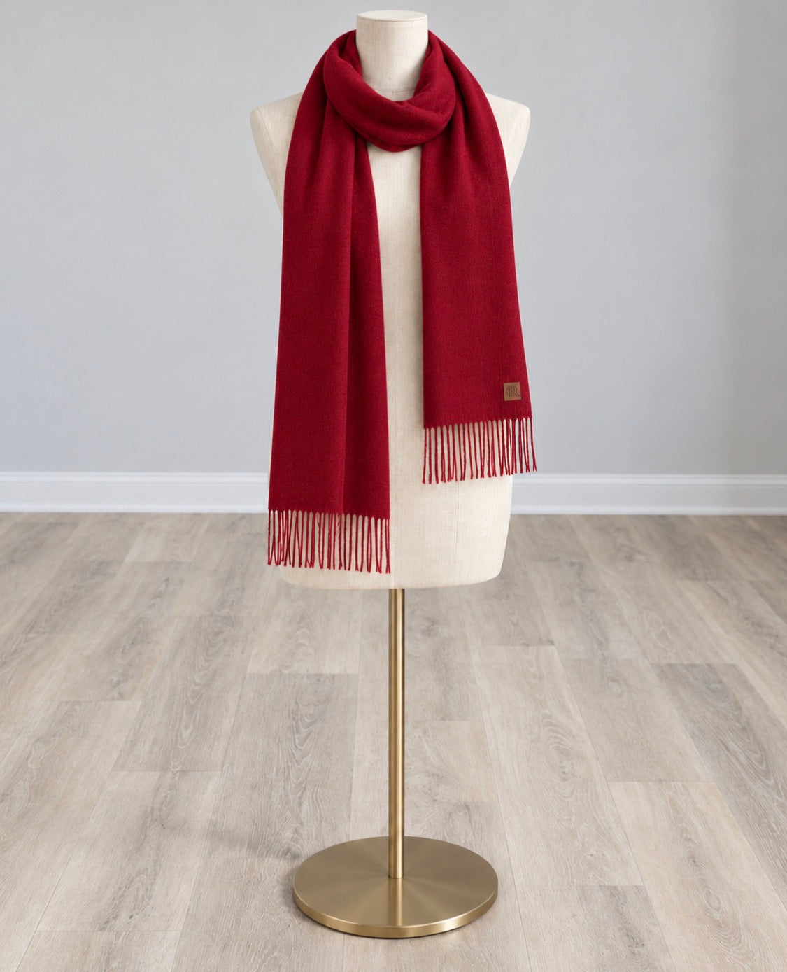 Solid red wool-feel scarf with fringed ends and a small label