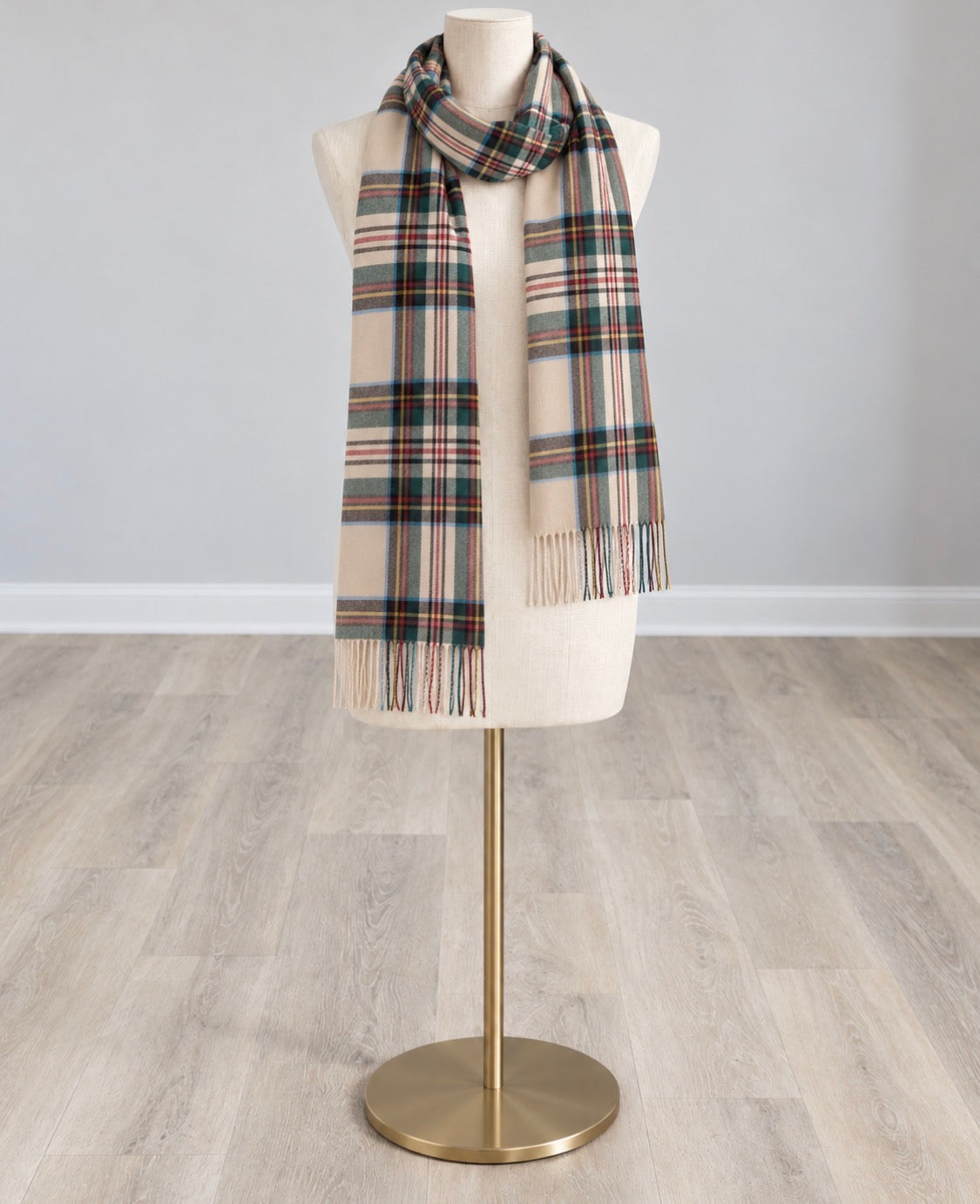 Tan plaid scarf with multicolor stripes and fringed ends, draped around a mannequin