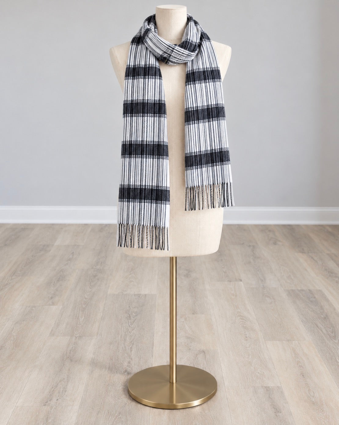 Black and white crinkle-texture scarf with striped bands and fringed ends, draped on a mannequin