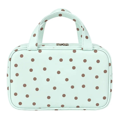 Mint travel makeup bag with brown polka dots, top handles, and a zip-around closure