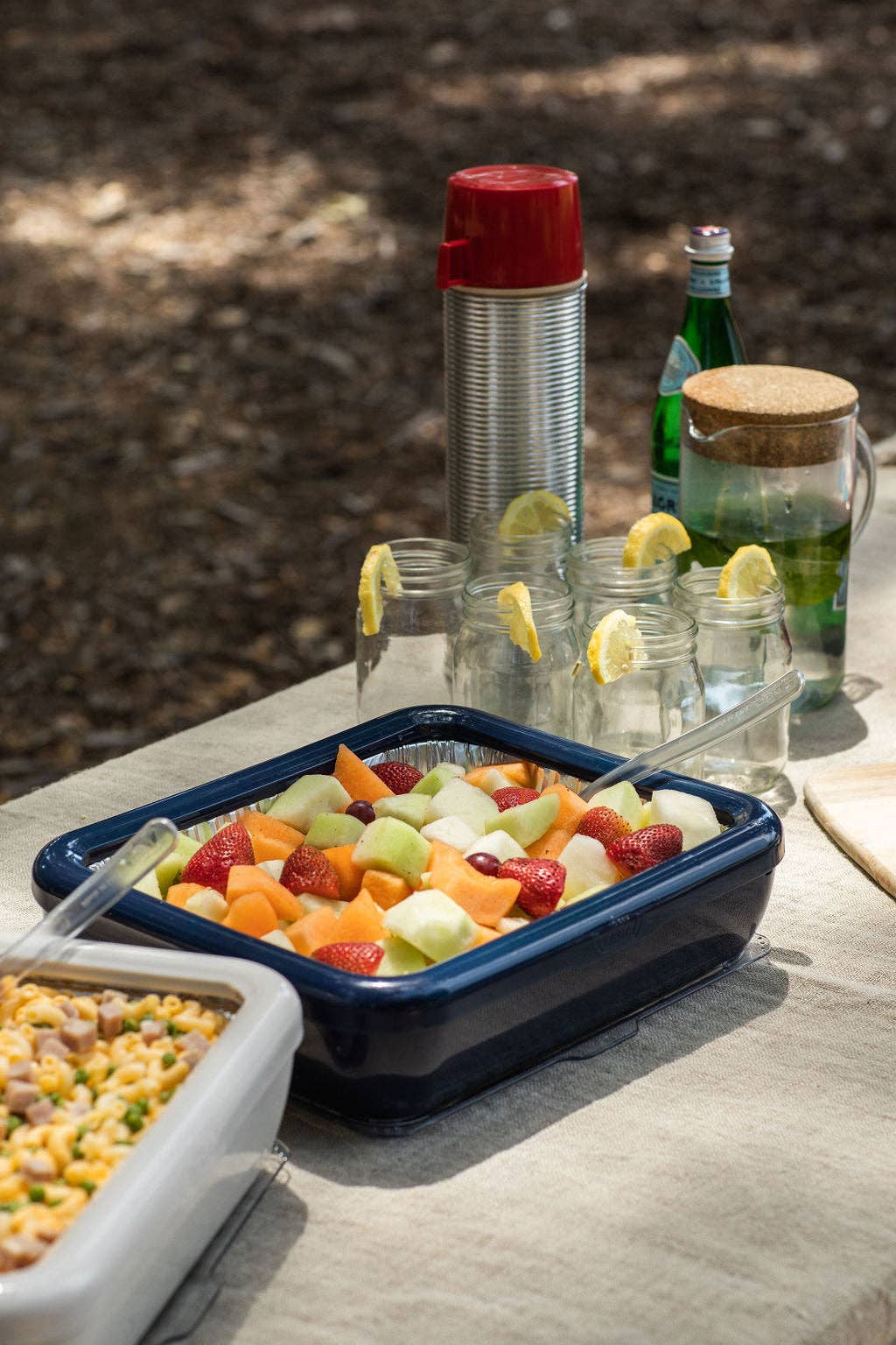 Blue navy foil pan carrier on a table with fruit and vegetable tray inserts