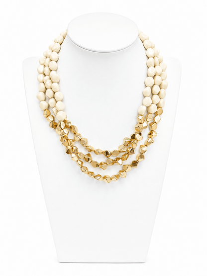 Angled acrylic pieces layered on a gold-tone chain