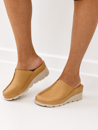 Leather clog with an ankle strap and closed toe