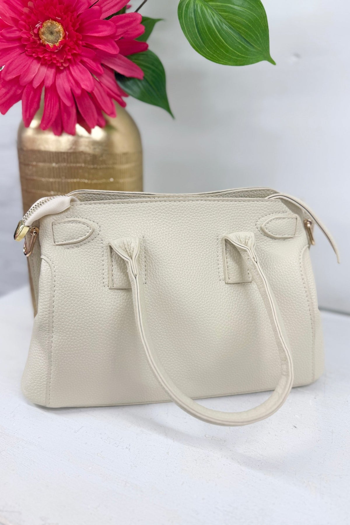 Beige structured satchel with a decorative scarf tie