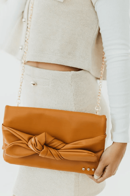 Bow-front clutch bag with a crossbody strap