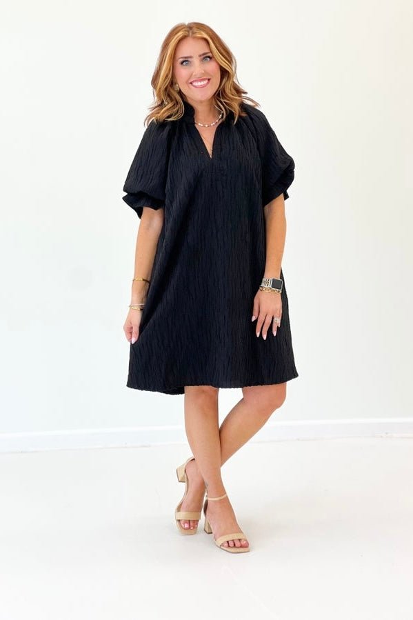 Black dress with frilled puff sleeves and a V-neckline