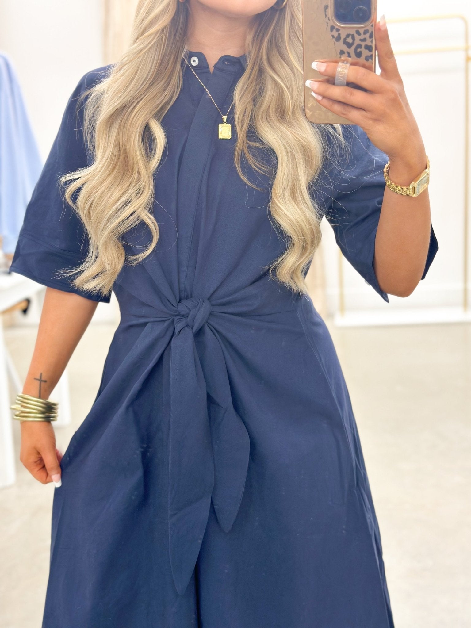 Navy dress falling to a midi length with a cinched waist