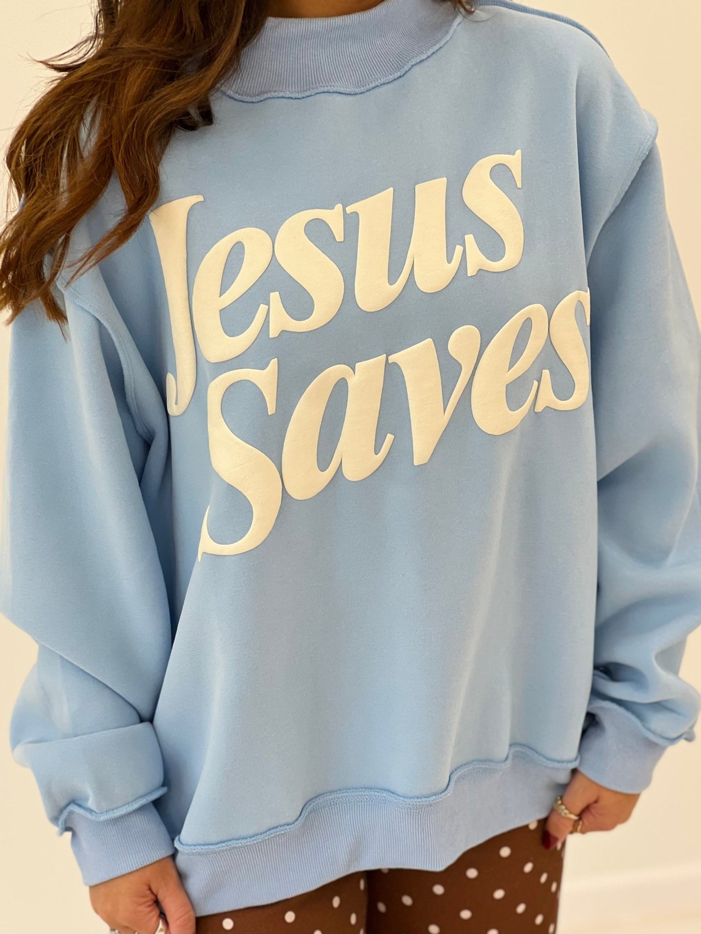 Light blue mock-neck sweatshirt with 'Jesus Saves' printed text