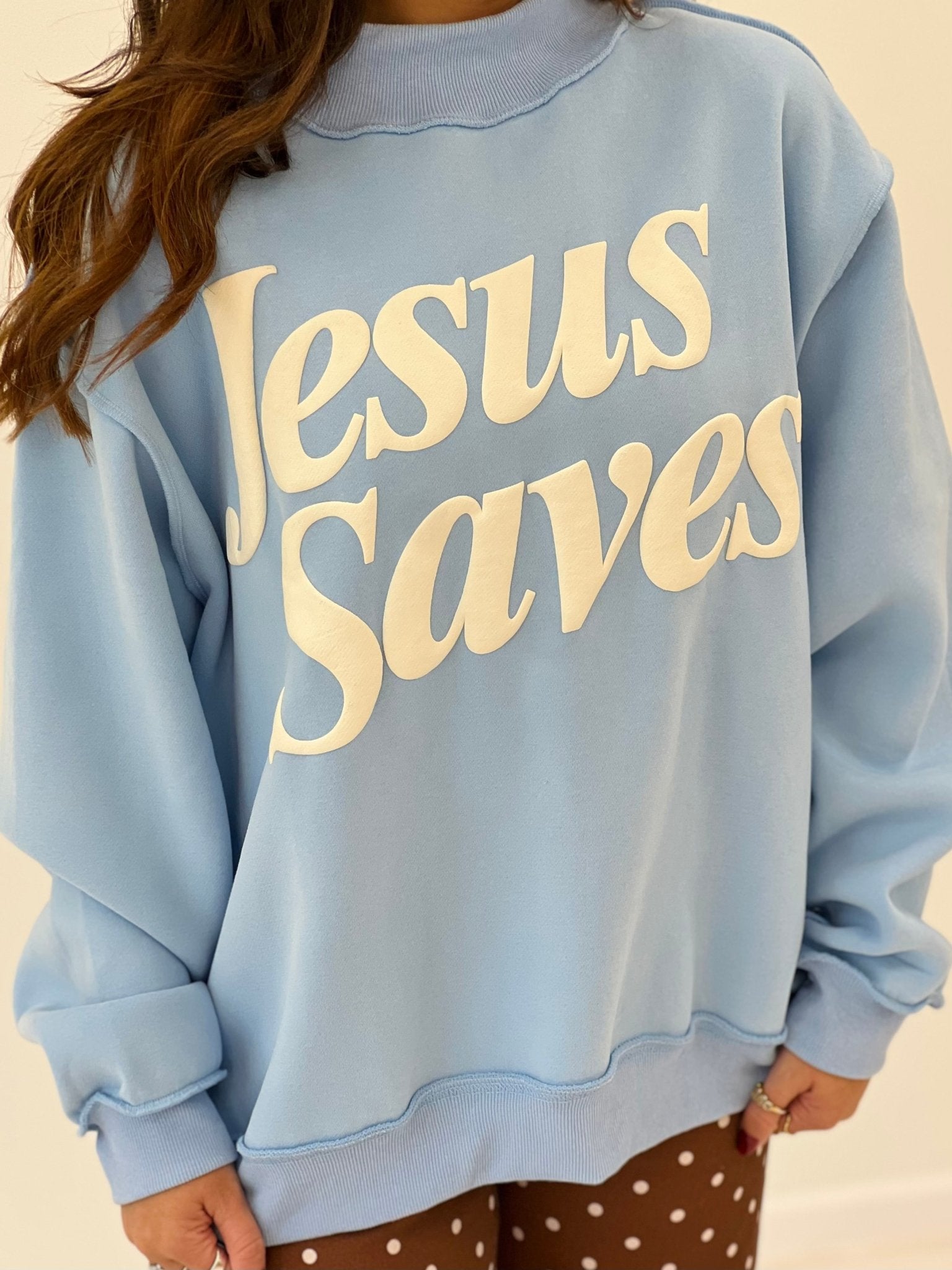 Light blue mock-neck sweatshirt with 'Jesus Saves' printed text