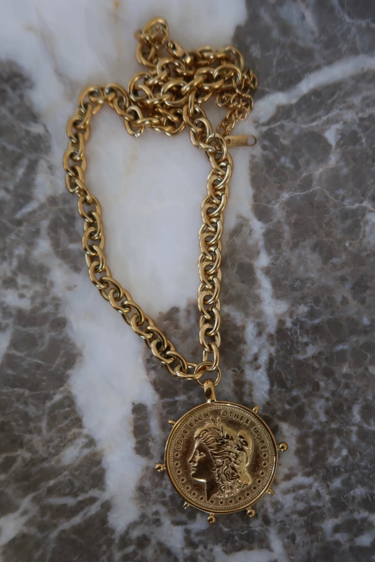 Round gold coin charm on a chain