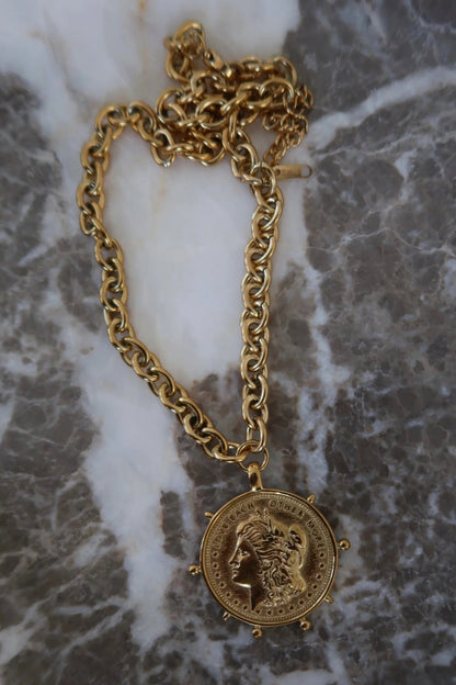 Round gold coin charm on a chain