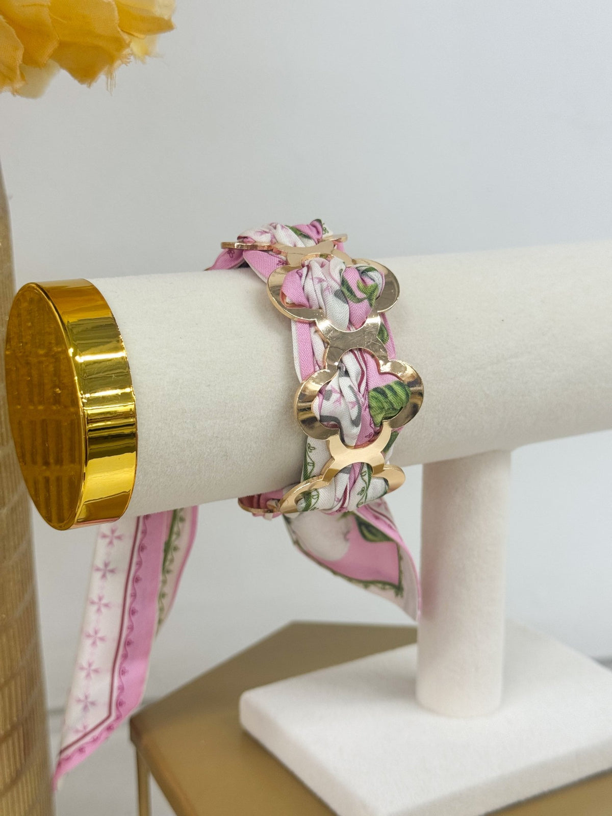 Pink scarf bracelet with a gold clover accent