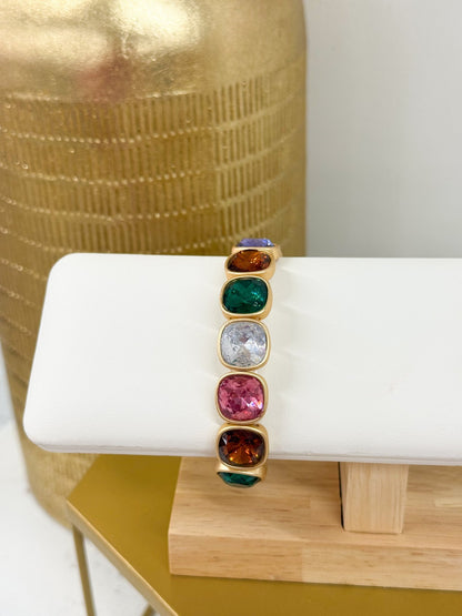 Cushion cut crystals along a metallic gold band