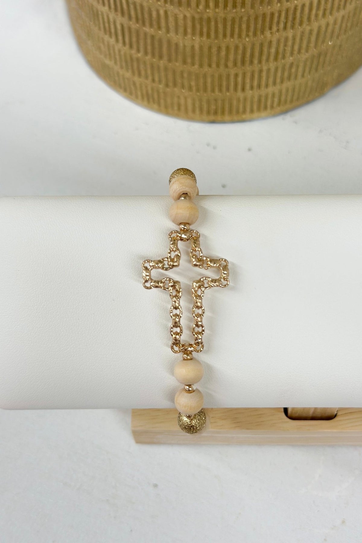Beaded bracelet with a worn gold openwork cross
